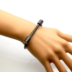 Vue détaillée d'un bracelet jonc noir minimaliste en fer à cheval sur un mannequin