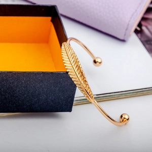 Elegante bracciale a foglia placcato oro con design minimalista a piuma aperta