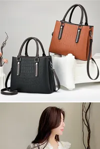 Close-up of crocodile pattern handbags in black and brown with metal hardware details