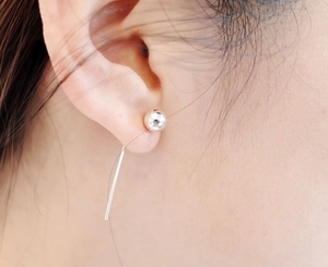 Macro view of 925 sterling silver ball stud earrings with elegant long bar drop tassels