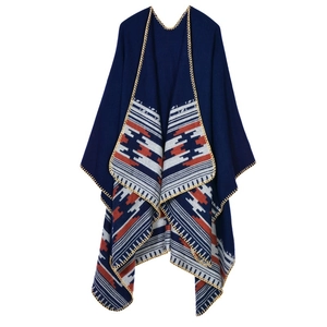 Close-up of bohemian navy knit poncho with geometric patterns and yellow stitch detail
