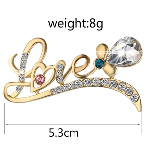Detail of 5.3cm gold Love brooch with pink and blue rhinestones, size and 8g weight marked