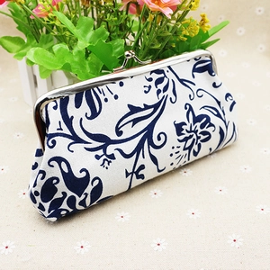 Close-up of blue and white ethnic floral fabric wallet with silver metal clasp closure
