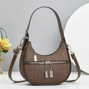 Détail du sac hobo en tissu texturé avec deux bandoulières et finitions brunes