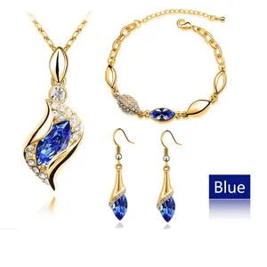Close-up of gold-plated jewelry set with blue marquise crystals and white gems