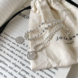 Makroaufnahme von 925er Sterling Silber Perlenarmbändern mit hohlen Smileyanhängern