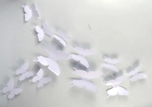 Group of 3D white PVC butterflies in various sizes creating a dynamic wall decoration
