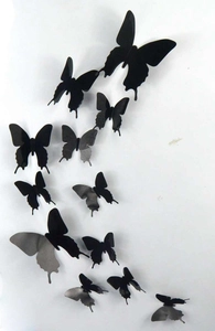 Macro shot of black 3D PVC butterflies arranged in a curved pattern on a white wall