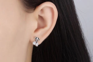 Detailed view of model wearing crystal-studded cherry stud earrings in silver finish