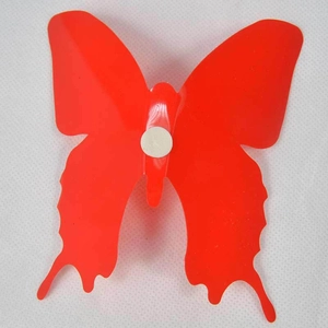 Detail view of red 3D butterfly wall sticker showing back with white adhesive pad