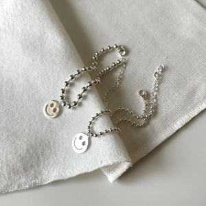 Detail von S925 Sterlingsilber Perlenarmbändern mit lächelndem Gesicht Anhänger