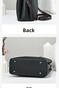 Detail view of the black tote bag showing the textured bottom with silver protective studs