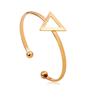 Dettaglio macro di un bracciale rigido dorato con elementi a triangolo lucidi