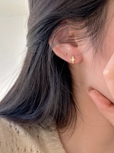 Gros plan de boucles d'oreilles étoiles dorées minimalistes de style coréen