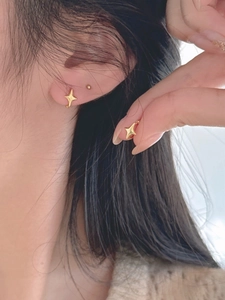 Vue détaillée de la boucle d'oreille étoile en argent doré portée à l'oreille