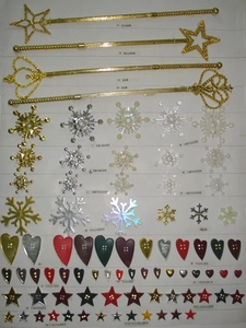Macro display of gold Merry Christmas stars, crowns and snowflakes for tree decoration