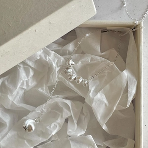 Detailed macro view of 925 sterling silver beaded necklace in elegant white jewelry gift box