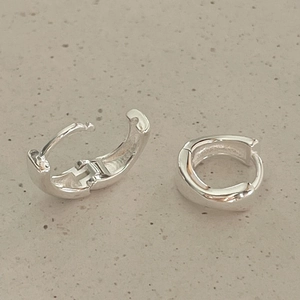 Close-up of minimalist 925 sterling silver huggie hoop earrings with polished finish