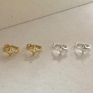 Vue détaillée de boucles d'oreilles étoiles en argent et or sur pierre