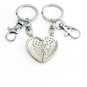 Close-up of interlocking silver heart keychains with textured finish and lobster clasps