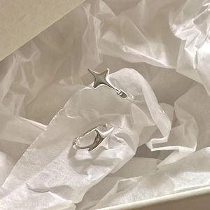 Détail des boucles d'oreilles créoles en argent 925 avec étoile à quatre branches