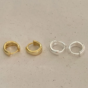 Macro detail of gold and silver sterling silver hoop earrings with a polished metal finish
