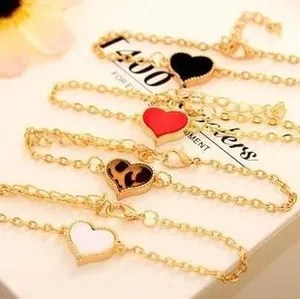 Set of four adjustable golden bracelets featuring colorful heart-shaped clover pendants