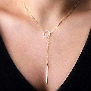 Detailed view of a gold Y-shaped necklace with a round buckle and vertical bar pendant