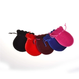 Close-up of velvet drawstring jewelry pouches in black, red, blue, and pink colors
