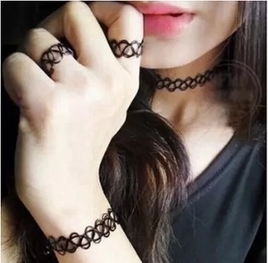 Close-up of black elastic tattoo choker set including bracelet and rings with spiral weaving