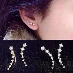 Close-up of asymmetric ear crawlers with sparkling cubic zirconia in gold and silver