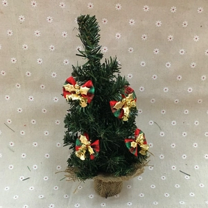 Mini Christmas tree with red plaid bows and golden bells on a rustic burlap base