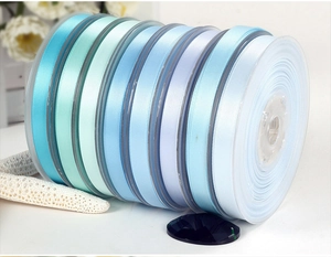 Close-up of premium satin polyester ribbons in light blue and purple gradient on spools