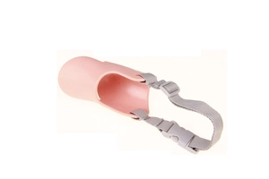 Detail of pink duck-bill dog muzzle featuring adjustable grey nylon strap and safety buckle
