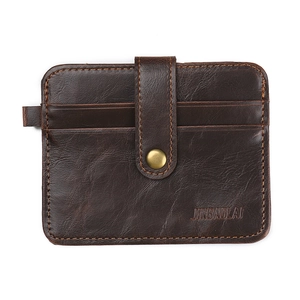 Detailed view of dark brown leather card holder with snap button and stitch texture