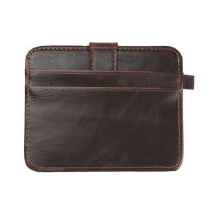 Detail of a brown leather card holder featuring orange contrast stitching and grain texture
