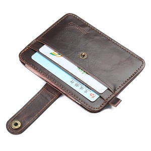 Macro shot of dark brown leather card holder with snap button and litchi texture