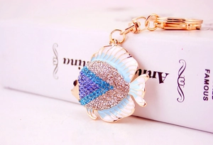 Macro view of crystal encrusted tropical fish keychain with blue rhinestones and gold finish