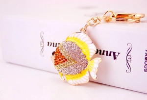 Close-up of golden tropical fish keychain with sparkling amber crystals and enamel