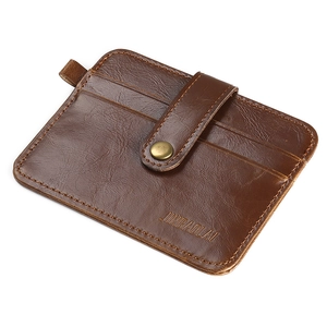 Detail view of brown leather card holder featuring reinforced stitching and snap button