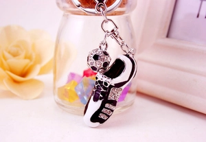Close-up of a black and white soccer shoe keychain with shiny rhinestones and football charm