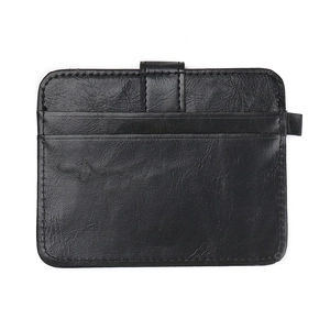 Macro shot of black pebbled leather card holder featuring stitching and secure strap