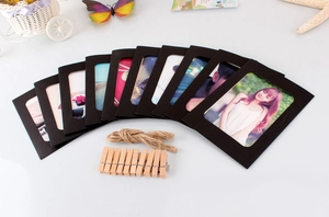 Detail of DIY hanging photo set with black paper frames, wooden clips, and hemp rope