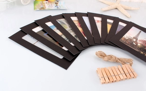 Detail of DIY photo display set with black paper frames, jute rope, and wooden clips