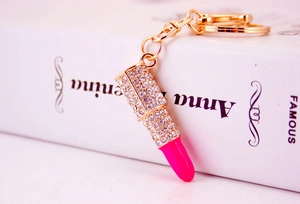 Macro shot of lipstick keychain featuring bright pink paste and sparkling rhinestones