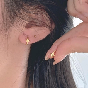 Boucles d'oreilles créoles étoiles en argent 925 plaqué or sur l'oreille