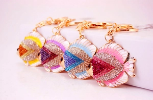Close-up of four colorful rhinestone tropical fish keychains in yellow, blue, and purple