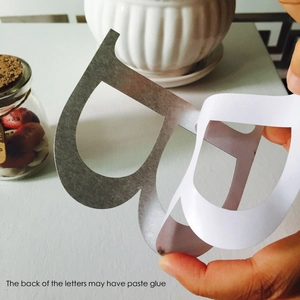 Detailed view of the adhesive backing on a light gold acrylic 3D mirror letter