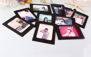 Close-up of matte black paper picture frames set with decorative sea starfish and butterfly