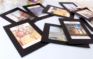Close-up of black cardboard hanging photo frames with sample scenic pictures and text
